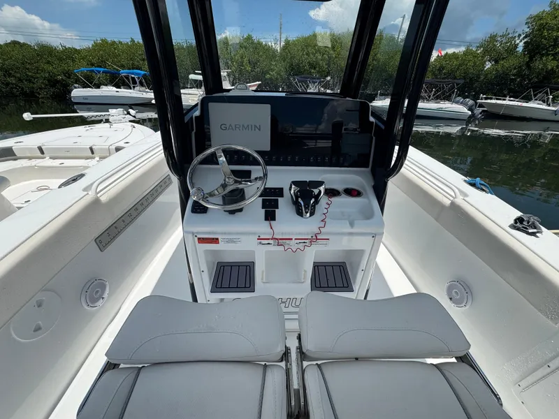 Slide: The Image of 2024 Sea Hunt Gamefish 27 boat cockpit with Garmin navigation system and steering wheel. - 21