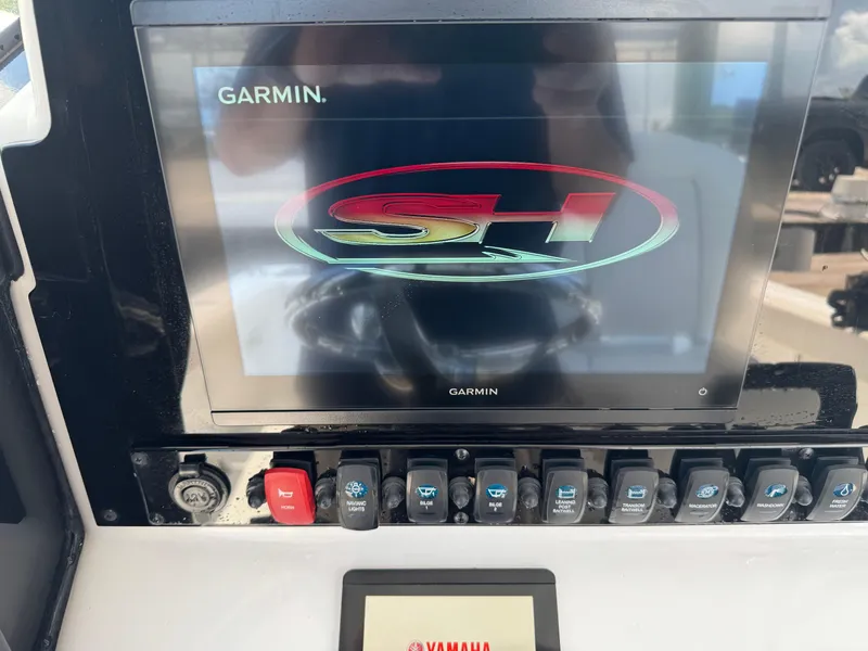 Slide: The Image of Garmin display on 2024 Sea Hunt Gamefish 27 boat dashboard with control switches. - 23