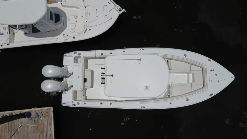 Slide: The Image of 2024 Sea Hunt Gamefish 27 Forward Seating boat, aerial view, docked with twin engines. - 3