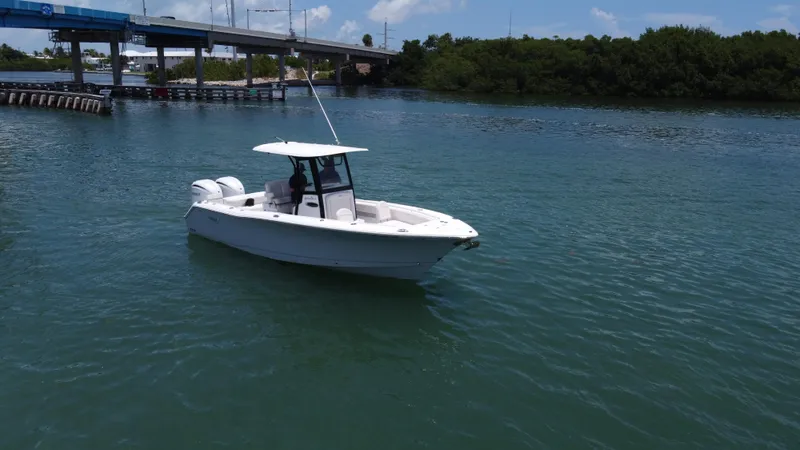Slide: The Image of 2024 Sea Hunt Gamefish 27 boat on calm water near a bridge. - 6
