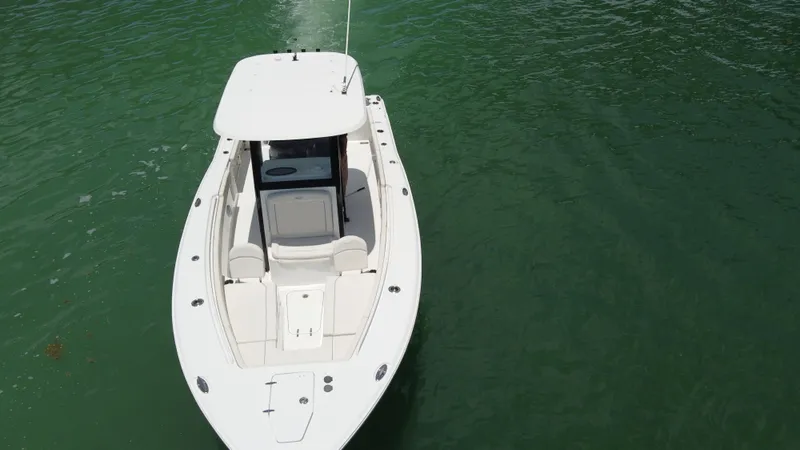 Slide: The Image of 2024 Sea Hunt Gamefish 27 Forward Seating boat on calm green water. - 7