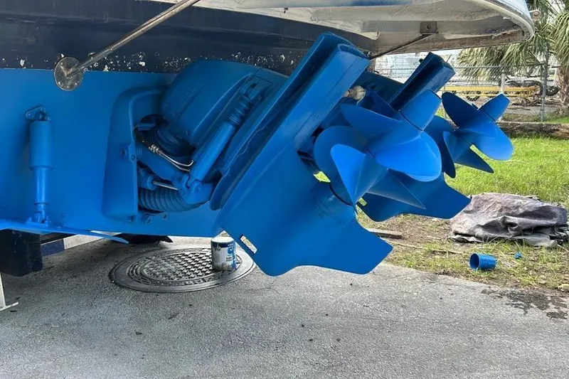 Slide: The Image of 2006 Rinker 300 Express Cruiser with blue-painted dual propellers and stern drive. - 14