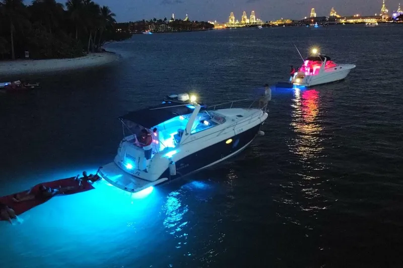 Slide: The Image of 2006 Rinker 300 Express Cruiser with blue lights on water at night. - 17