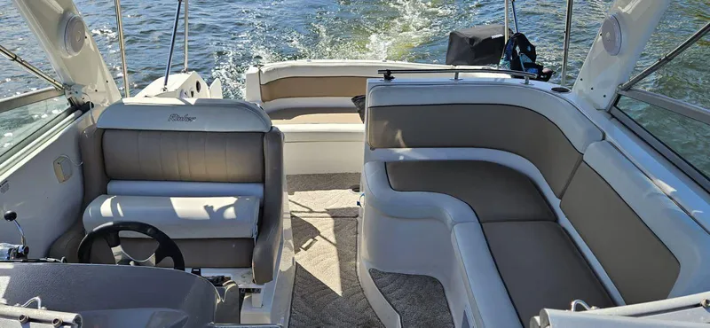 Slide: The Image of 2006 Rinker 300 Express Cruiser interior with seating and steering wheel on open water. - 3