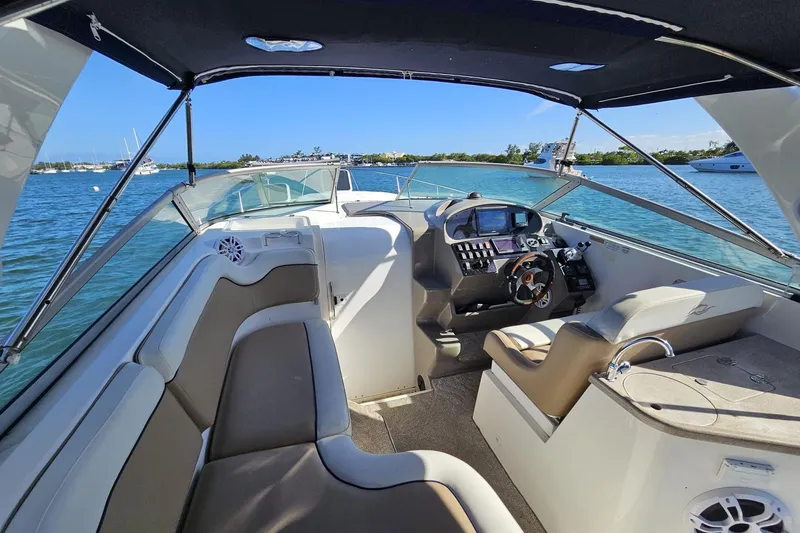 Slide: The Image of 2006 Rinker 300 Express Cruiser interior with helm, seating, and scenic water view. - 6