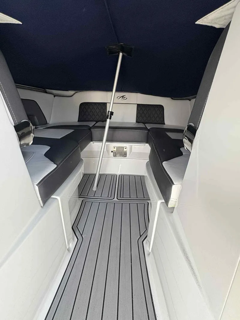Slide: The Image of 2023 Monterey M65 boat interior with cushioned seating and sleek flooring. - 19