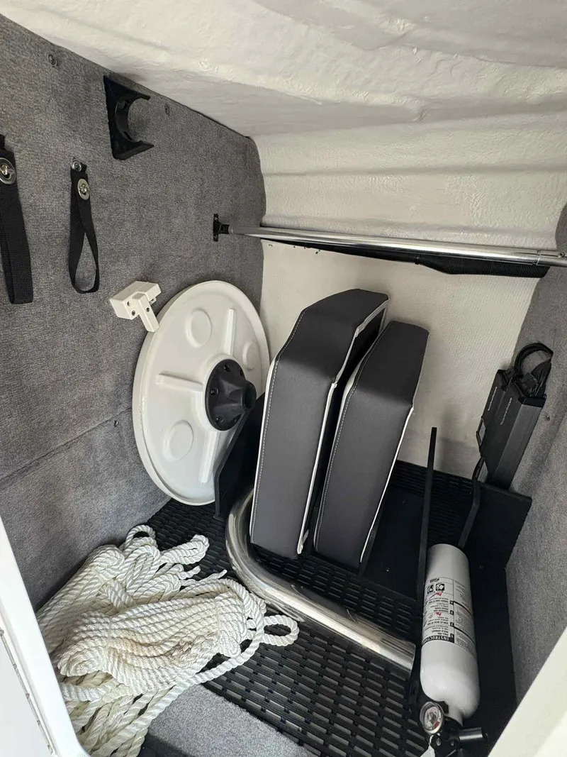Slide: The Image of Storage compartment of 2023 Monterey M65 boat with rope, cushions, and fire extinguisher. - 21