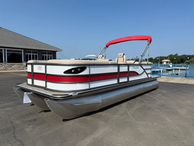 Slide: The Image of 2026 Bentley Pontoons Legacy 223 Navigator with red accents, docked on a sunny day. - 5