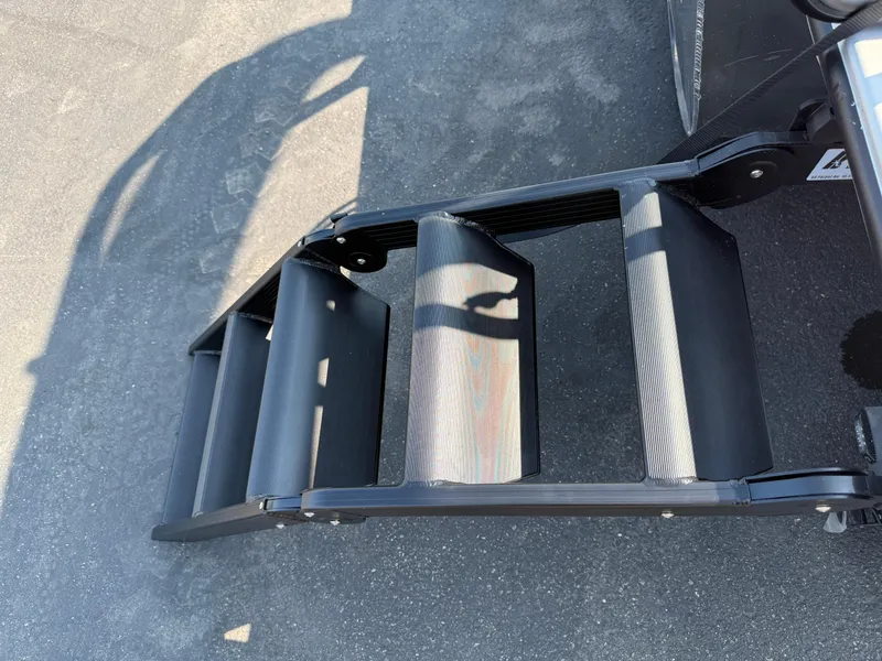 Slide: The Image of Bentley Pontoons Legacy 223 Navigator 2026, close-up of sturdy black steps on pavement. - 9