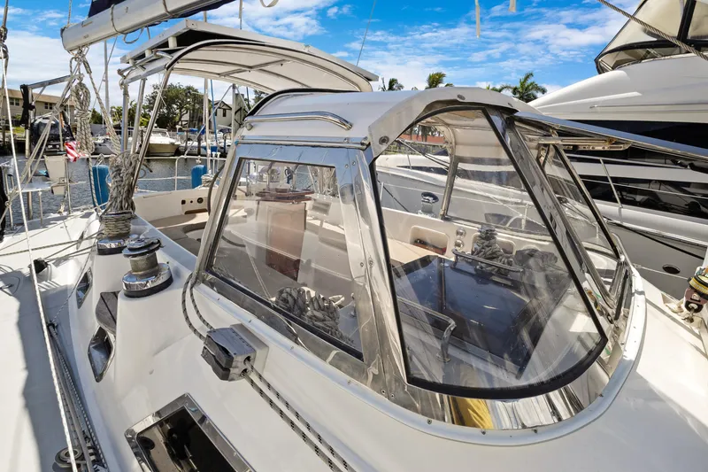 Slide: The Image of 2004 Hylas 46 sailboat cockpit with clear enclosure, docked in a marina. - 10