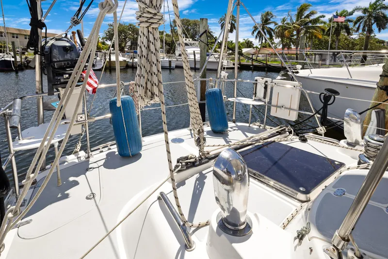 Slide: The Image of Deck view of a 2004 Hylas 46 sailboat docked in a sunny marina. - 13