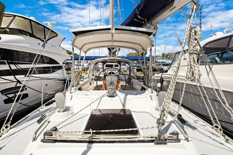 Slide: The Image of 2004 Hylas 46 sailboat docked between yachts under a clear blue sky. - 16
