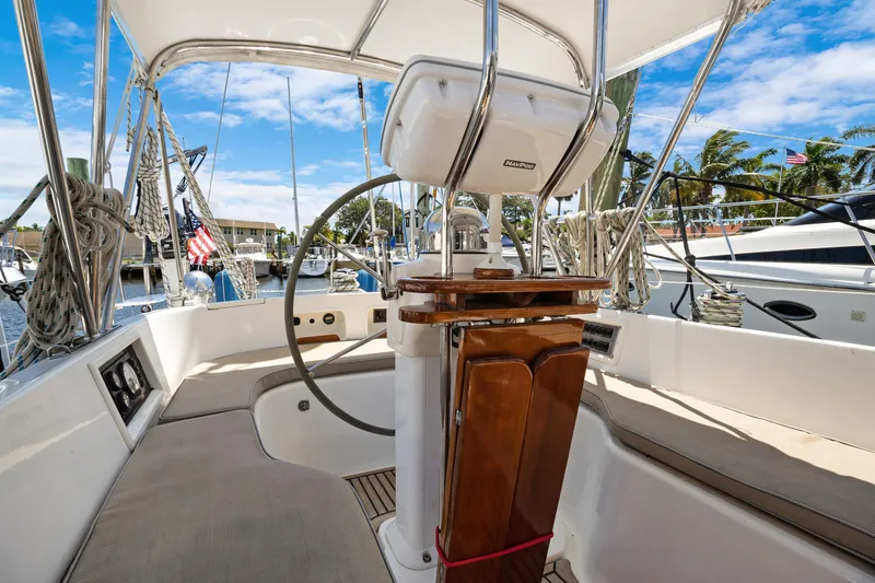 Slide: The Image of Cockpit of 2004 Hylas 46 sailboat with steering wheel and seating, docked at marina. - 22