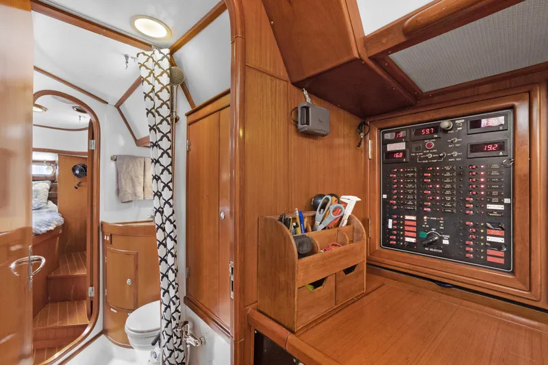 Slide: The Image of Interior of 2004 Hylas 46 yacht featuring control panel, bathroom, and wooden cabinetry. - 40