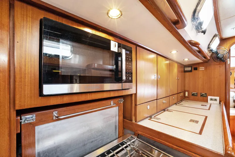 Slide: The Image of Luxurious 2004 Hylas 46 yacht kitchen with wood cabinetry and modern appliances. - 47