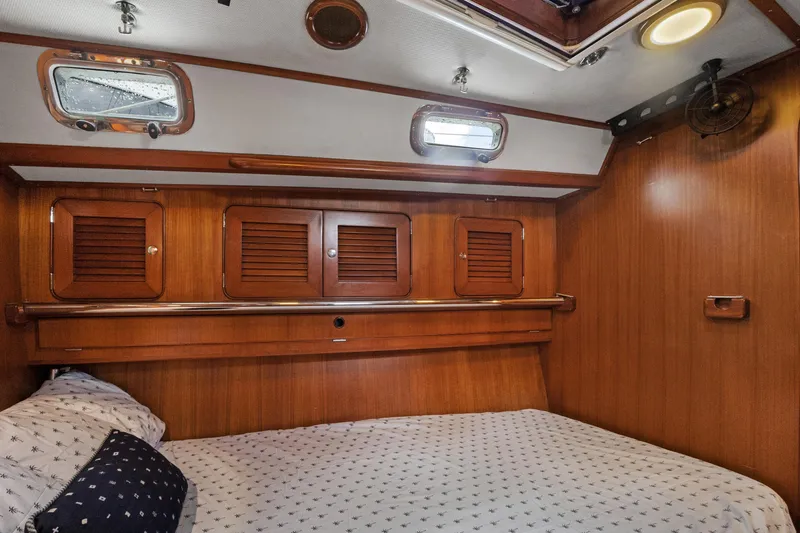 Slide: The Image of Cozy cabin interior of 2004 Hylas 46 yacht with wooden paneling and portholes. - 55