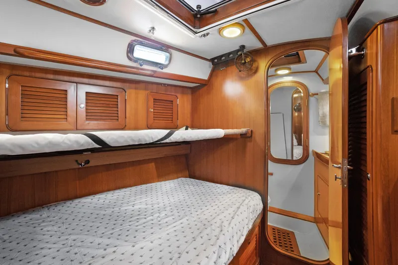 Slide: The Image of Cozy cabin interior of 2004 Hylas 46 yacht with wooden finish and comfortable bedding. - 58