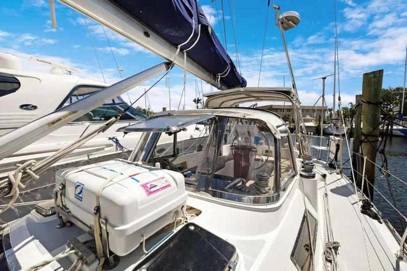 Slide: The Image of 2004 Hylas 46 sailboat docked, featuring cockpit and rigging under a clear blue sky. - 6