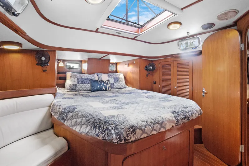 Slide: The Image of Luxurious 2004 Hylas 46 yacht cabin with skylight, wood finish, and cozy bedding. - 64