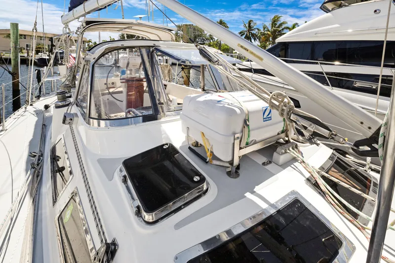 Slide: The Image of 2004 Hylas 46 sailboat deck with lifeboat, docked in sunny marina. - 8