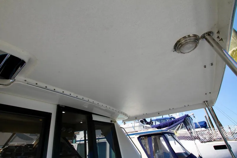 Slide: The Image of 2002 Bayliner 3988 boat deck with overhead light and railing, docked at marina. - 15