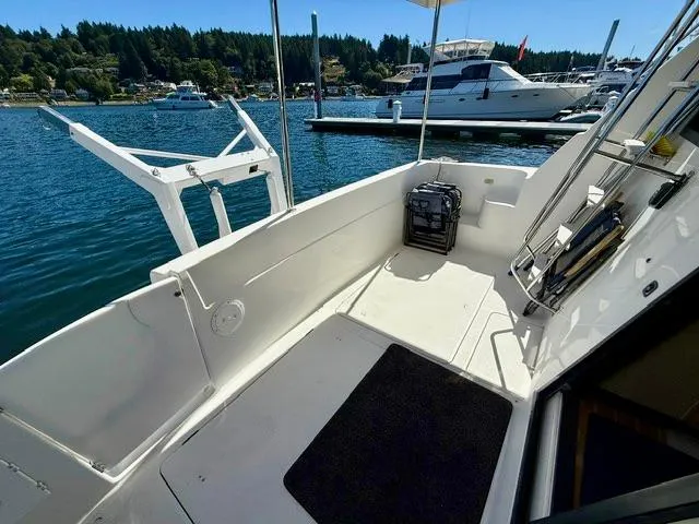 Slide: The Image of 2002 Bayliner 3988 yacht deck with marina view, featuring clean white surfaces and moored boats. - 17