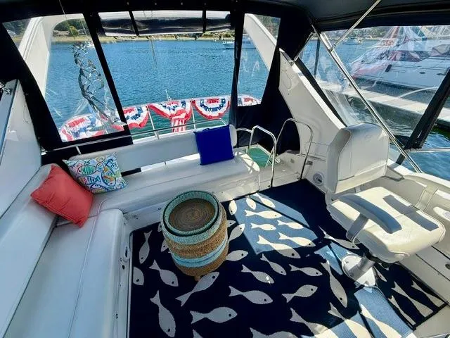 Slide: The Image of 2002 Bayliner 3988 yacht interior with seating, nautical decor, and water view. - 19