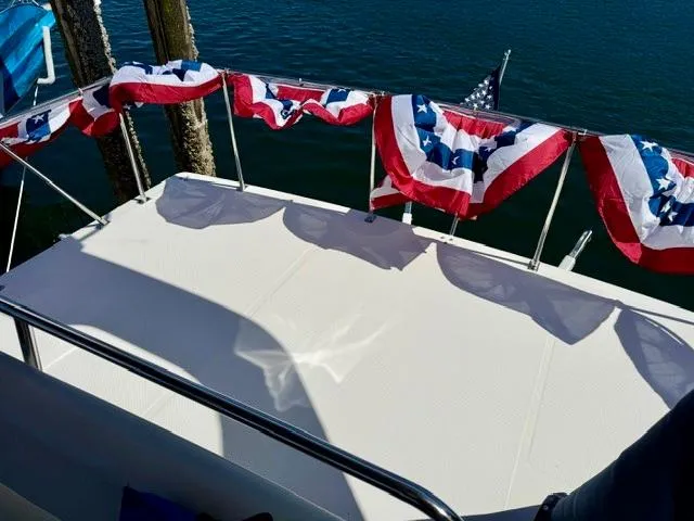 Slide: The Image of Bayliner 3988 boat deck with patriotic bunting, 2002 model, docked by the water. - 24