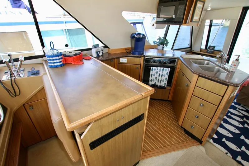 Slide: The Image of 2002 Bayliner 3988 yacht kitchen with modern appliances and wooden cabinetry. - 35