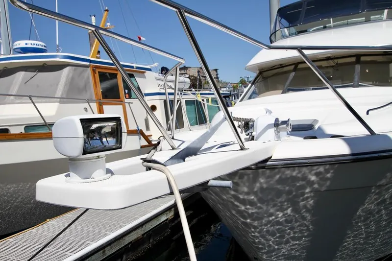 Slide: The Image of 2002 Bayliner 3988 yacht docked, featuring a spotlight and railing, with neighboring boats visible. - 4