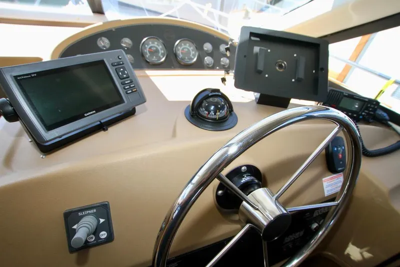 Slide: The Image of 2002 Bayliner 3988 helm with steering wheel, compass, and navigation equipment. - 40