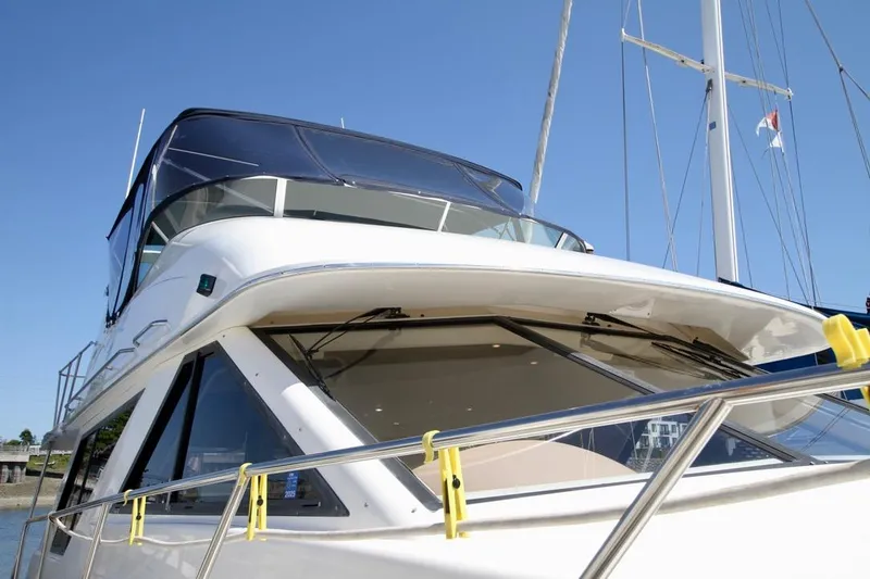 Slide: The Image of 2002 Bayliner 3988 yacht with sleek design and modern features, docked under clear blue sky. - 6
