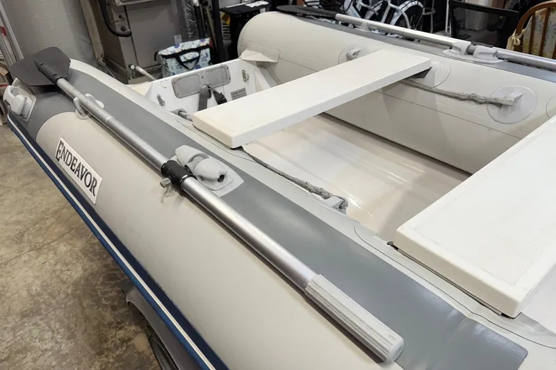 Slide: The Image of Inflatable boat with oars, labeled "Endeavor," associated with 2002 Bayliner 3988 Motoryacht. - 82