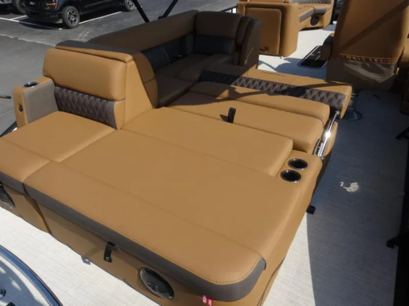 Slide: The Image of Luxurious seating on 2025 Harris Cruiser 250 LUX boat, featuring tan upholstery and cup holders. - 6