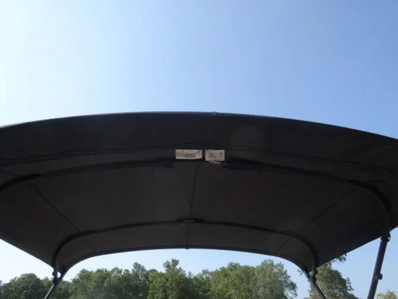 Slide: The Image of 2025 Harris Cruiser 250 LUX boat canopy against clear blue sky. - 15