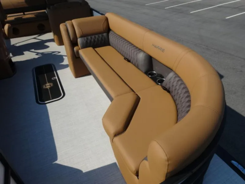 Slide: The Image of Luxurious seating on 2025 Harris Cruiser 250 LUX boat, featuring tan upholstery and cup holders. - 3