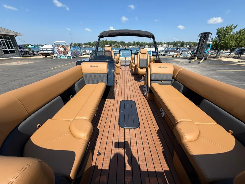Slide: The Image of 2026 Bentley Pontoons Elite 253 QSB with tan seating, docked at a marina. - 13