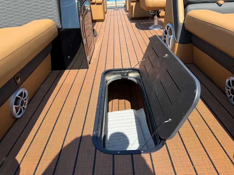 Slide: The Image of 2026 Bentley Pontoons Elite 253 QSB interior with open storage compartment on deck. - 16