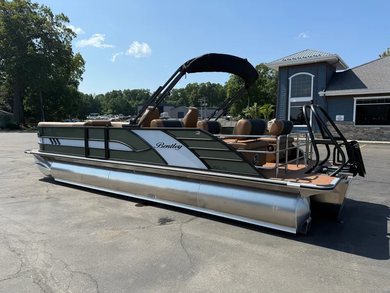 Slide: The Image of 2026 Bentley Pontoons Elite 253 QSB pontoon boat parked outdoors on a sunny day. - 2