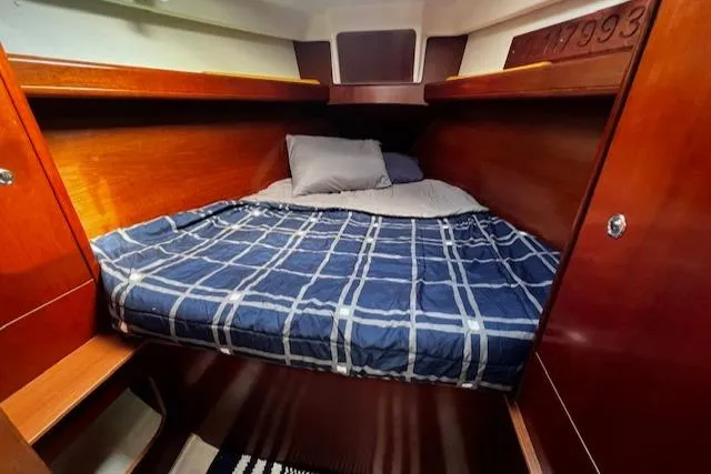 Slide: The Image of Cozy cabin interior of 2006 Beneteau 343 Sloop with plaid bedding and wooden finish. - 14