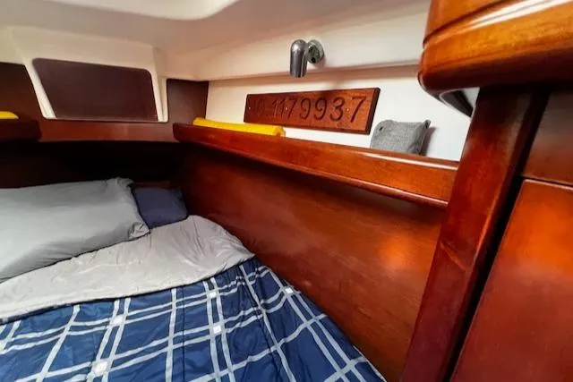 Slide: The Image of Cozy cabin interior of 2006 Beneteau 343 Sloop with wood finish and plaid bedding. - 15