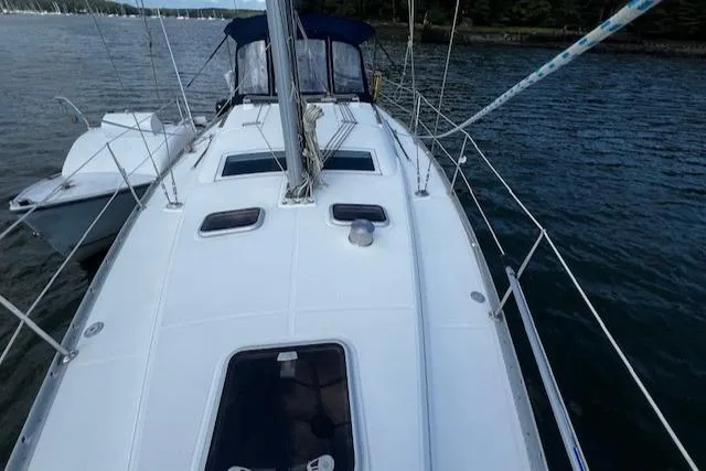 Slide: The Image of 2006 Beneteau 343 Sloop sailboat on calm water, showcasing deck and rigging. - 37