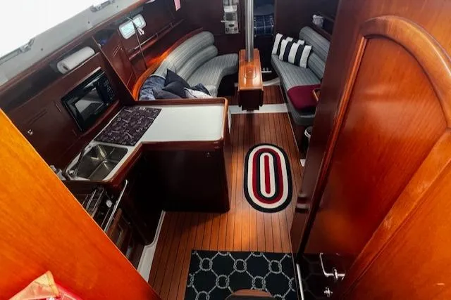 Slide: The Image of Interior of 2006 Beneteau 343 Sloop with wood finish, kitchen, and seating area. - 4
