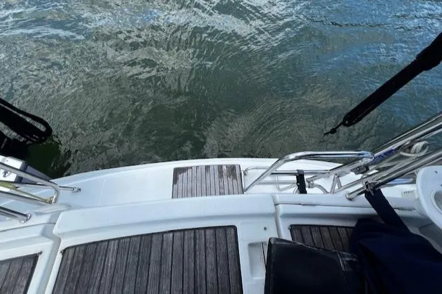 Slide: The Image of Beneteau 343 Sloop 2006 stern view with wooden deck and water backdrop. - 46