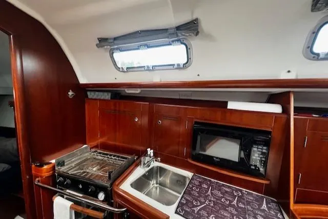 Slide: The Image of 2006 Beneteau 343 Sloop interior kitchen with stove, sink, and microwave. - 9