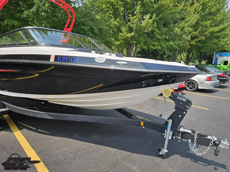 Slide: The Image of 2019 Yamaha AR195 boat on trailer in parking lot, surrounded by trees and cars. - 12