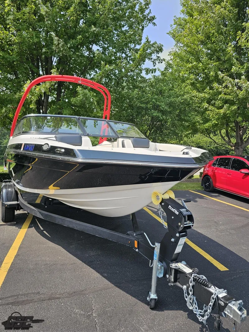 Slide: The Image of 2019 Yamaha AR195 boat on trailer, parked in a lot with trees in the background. - 13