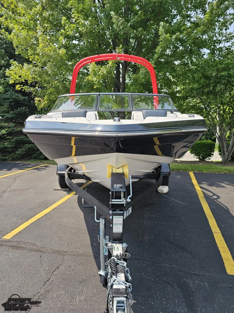 Slide: The Image of 2019 Yamaha AR195 boat on trailer, parked in lot with trees in background. - 14