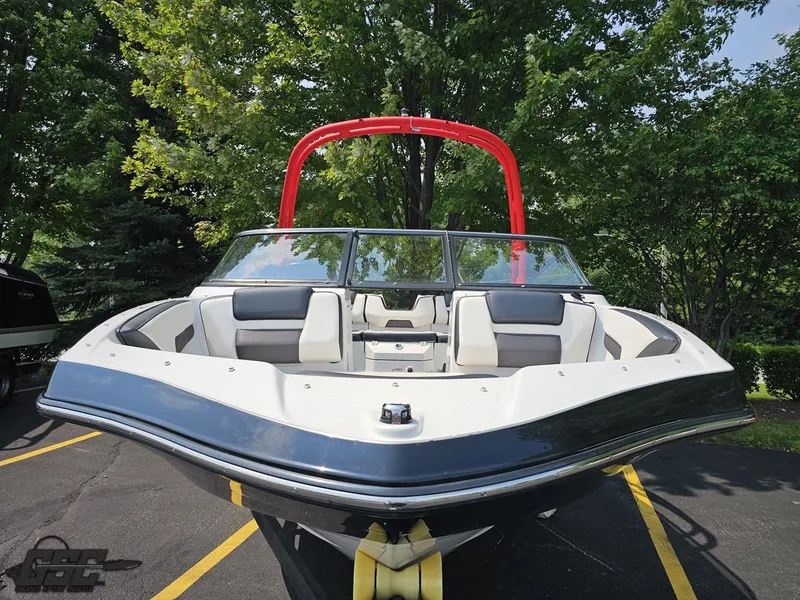 Slide: The Image of 2019 Yamaha AR195 boat with red wakeboard tower, parked on asphalt, surrounded by trees. - 15