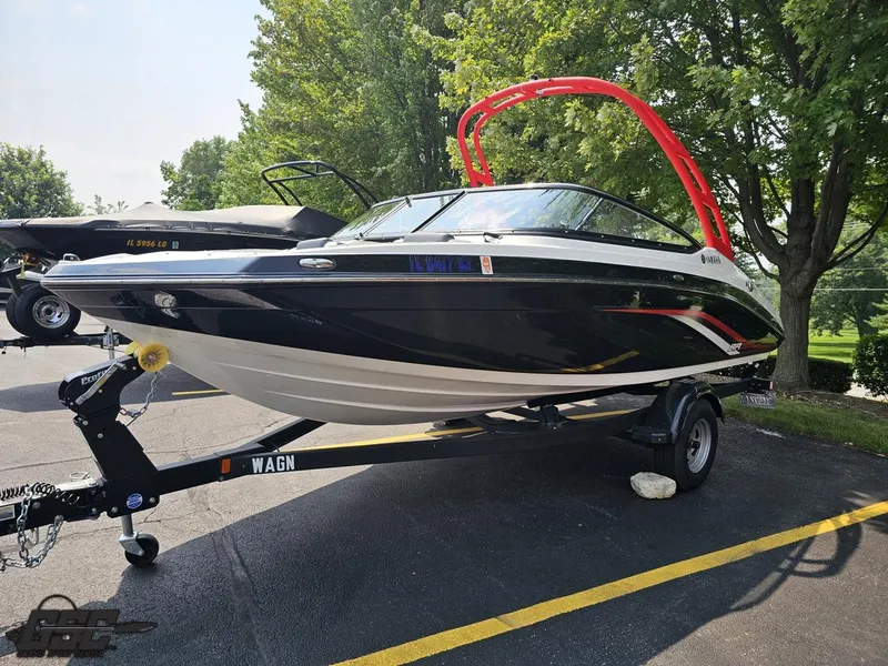 Slide: The Image of 2019 Yamaha AR195 boat on trailer, parked outdoors with trees in background. - 17